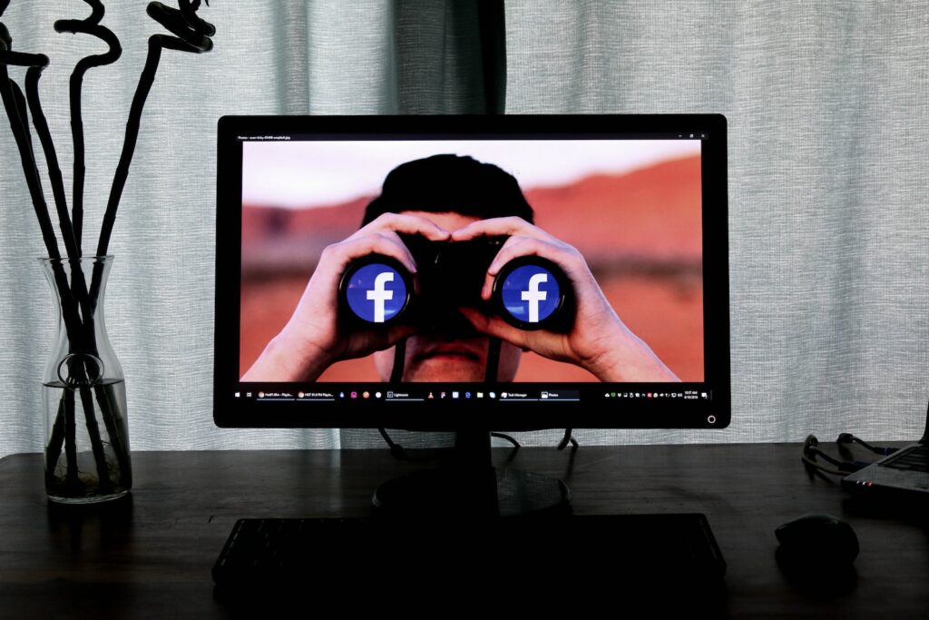 television showing man using binoculars searching facebook groups